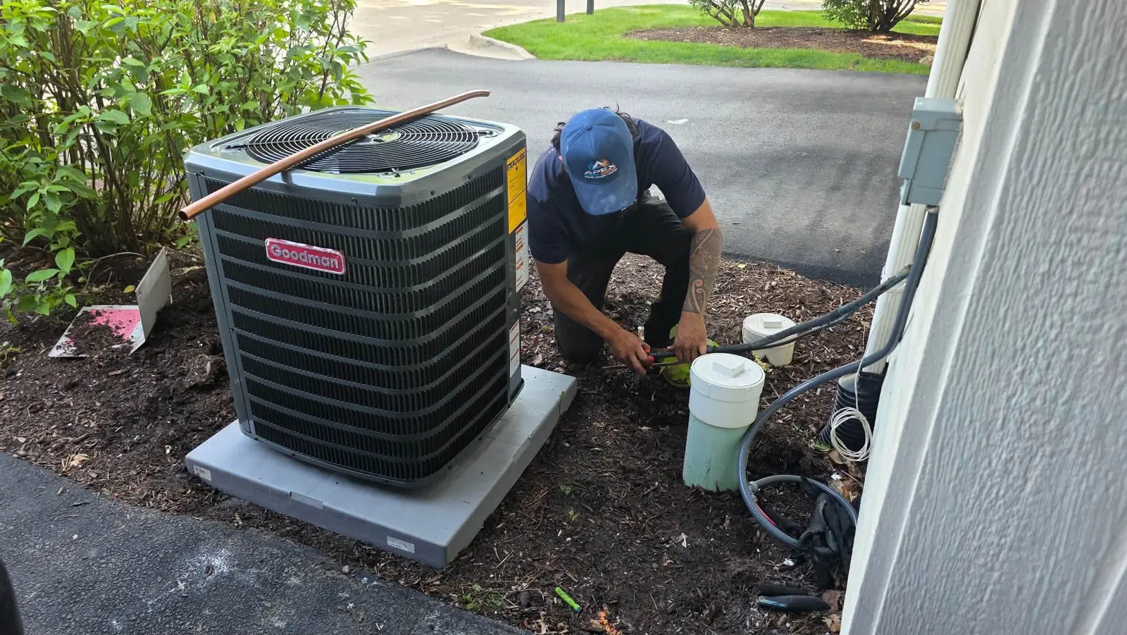 Apex Climate Control technician installing a new Goodman air conditioner condenser