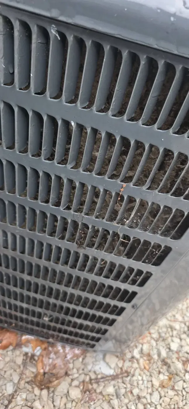 Debris accumulated on an air conditioner condenser coil, a common efficiency and lifespan problem