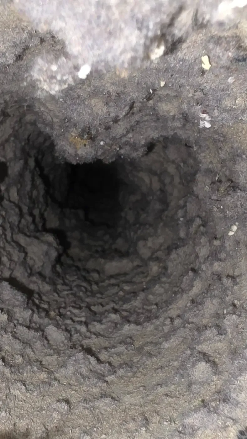 A dryer vent packed with lint before cleaning